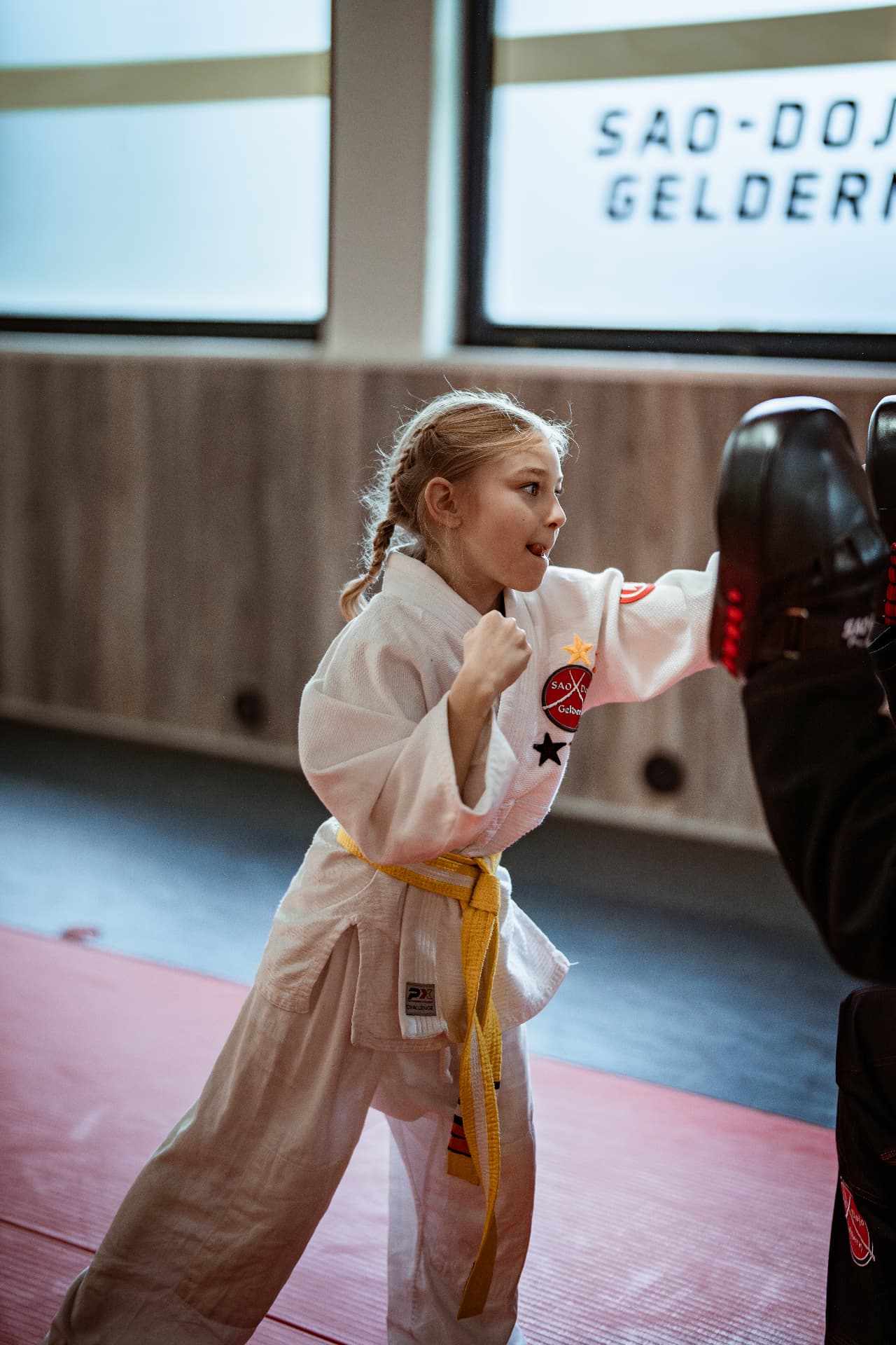 Mädchen im weißen Anzug trainiert konzentriert am schwarzen Schlagpolster im SAO-DOJO Geldern