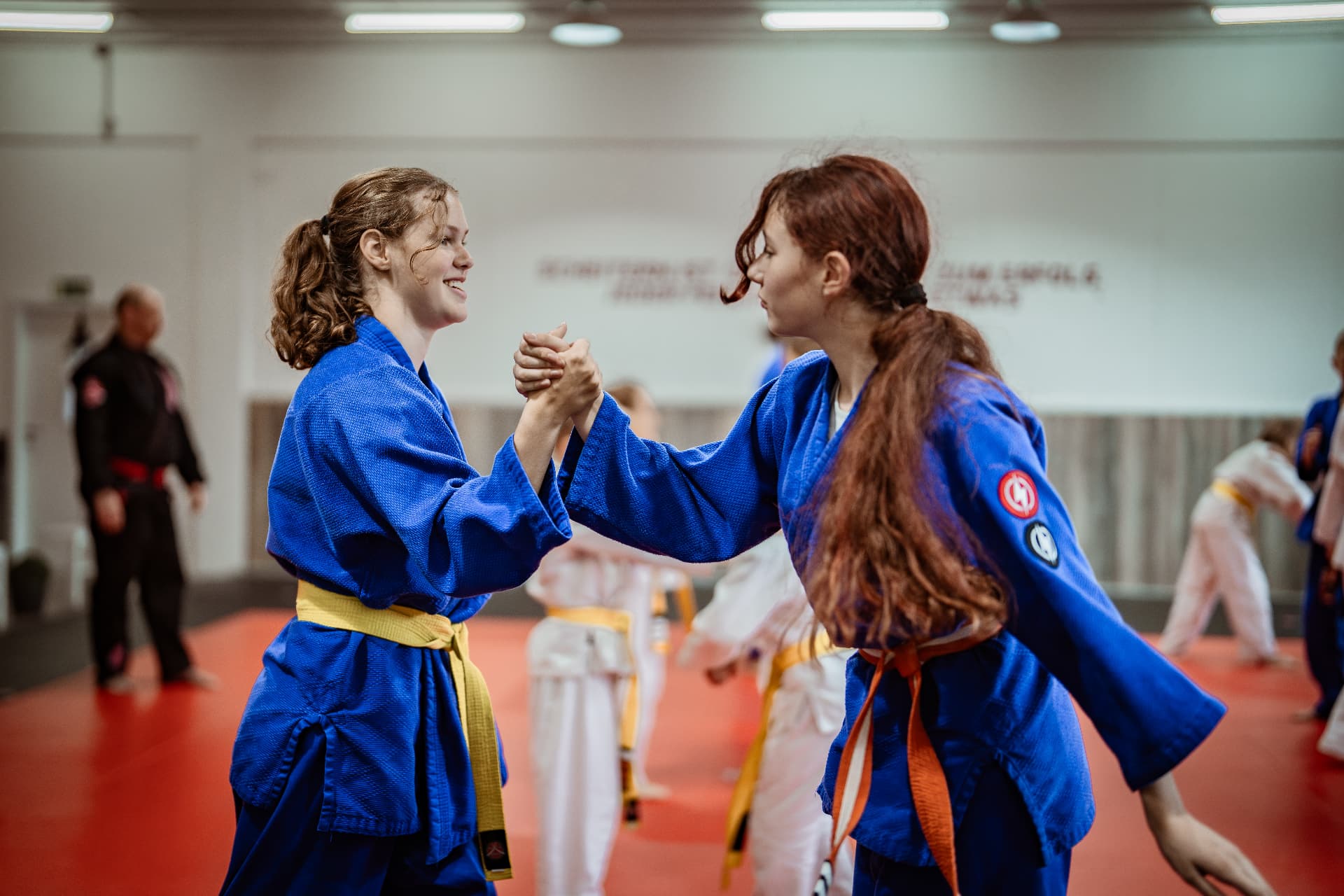 Zwei Jugendliche in blauen Anzügen greifen sich beim Training im SAO-DOJO Geldern an den Händen